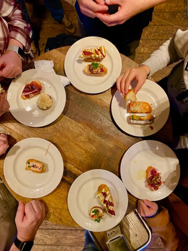 best-barcelona-food-tour-pinchos-the-barcelona-feeling 01 View from above down to a table full of plates with Spanish tapas called Ponchos.