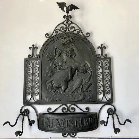 A metal art work showing Saint George slaying a dragon.