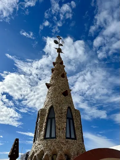 The roof top of Gaudí's Palau Guëll has castle like features such as this spiral tower with a bat on top.