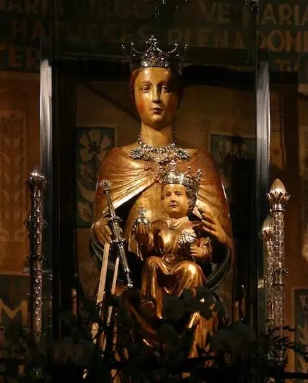 A wooden sculpture of the Saint Lady of Mery with baby Jesus on her knees.